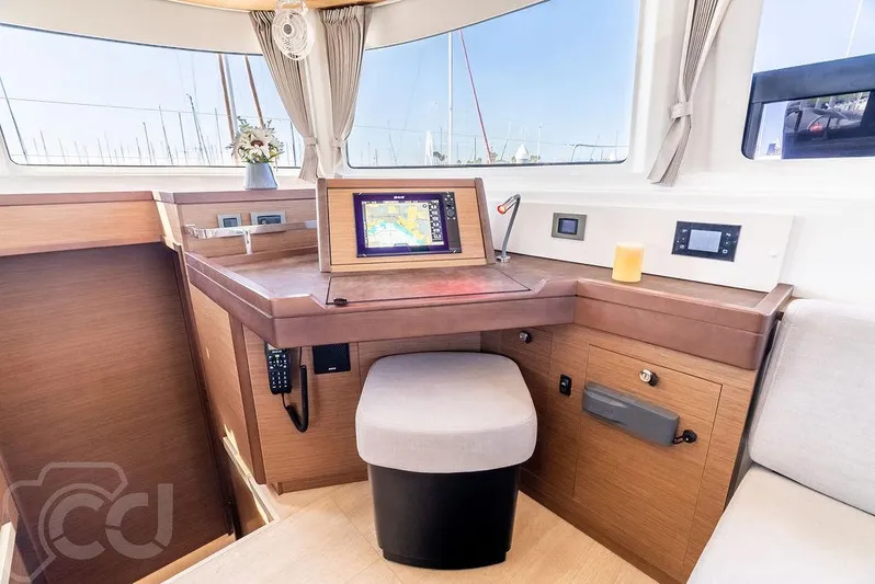 Flying B Yacht Photos Pics Modern navigation station inside 2021 Lagoon 46 catamaran with electronic display and comfortable seating.