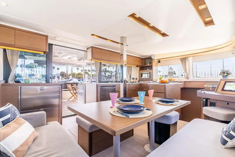Flying B Yacht Photos Pics Luxurious interior of 2021 Lagoon 46 catamaran with modern dining area and scenic marina view.