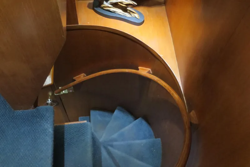 Water Doctor Yacht Photos Pics Spiral staircase on 1988 DeFever 53POC yacht with wooden and carpeted design.