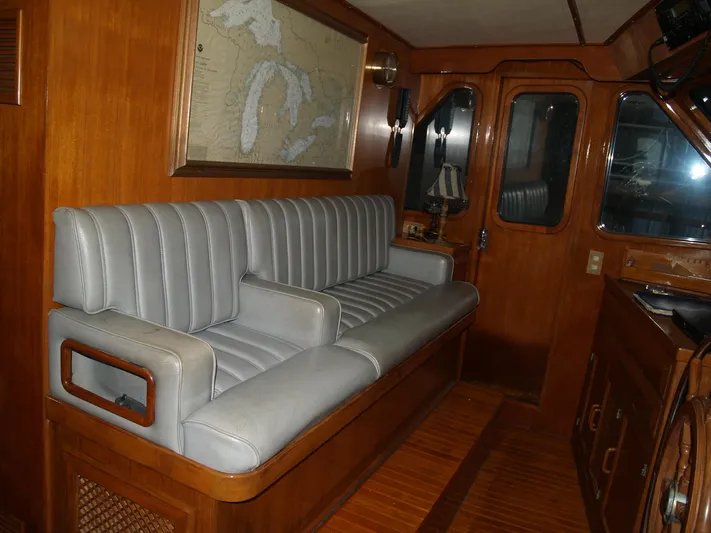 Water Doctor Yacht Photos Pics 1988 DeFever 53POC yacht interior with gray seating and wooden accents.