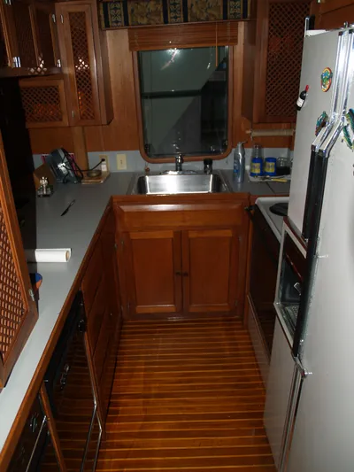 Water Doctor Yacht Photos Pics 1988 DeFever 53POC yacht kitchen with wooden cabinetry and flooring.