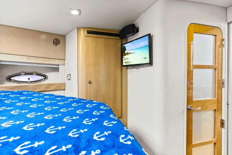 Black Diamond Yacht Photos Pics Interior of 2016 Formula 45 Yacht cabin with anchor-patterned bedding and wall-mounted TV.