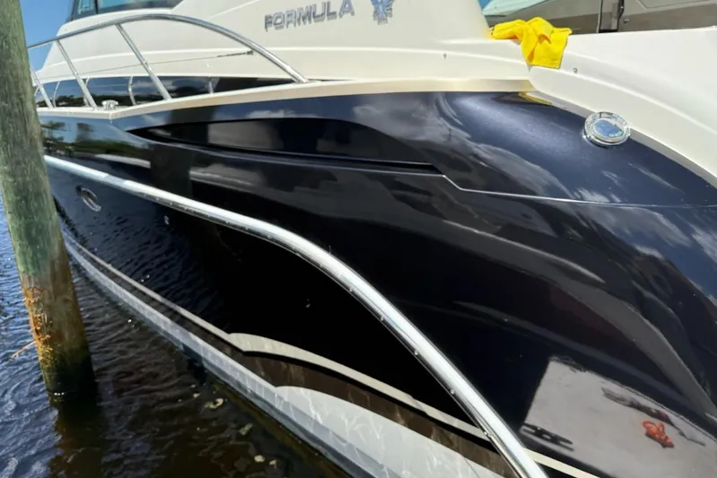 Black Diamond Yacht Photos Pics 2016 Formula 45 Yacht with sleek black hull docked by a wooden post.