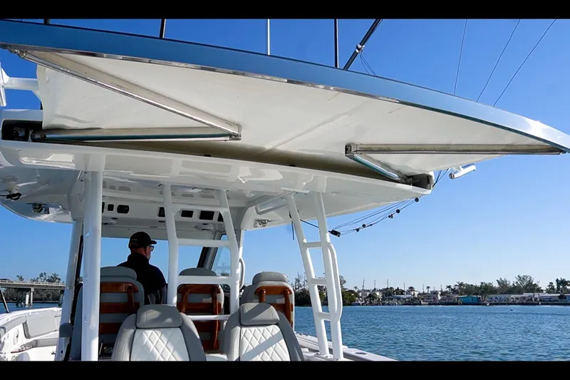 Almost Heaven Yacht Photos Pics 2024 Everglades 395 Center Console boat with canopy, featuring luxurious seating and ocean view.