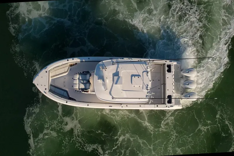 Almost Heaven Yacht Photos Pics Aerial view of 2024 Everglades 395 Center Console boat cruising on water.