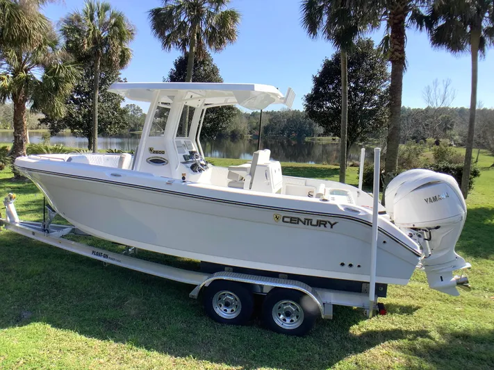 Highly Upgraded - 2025 Century 2600 Cc Yacht Photos Pics 2025 Century 2600 Center Console boat on trailer, parked near palm trees and a lake.