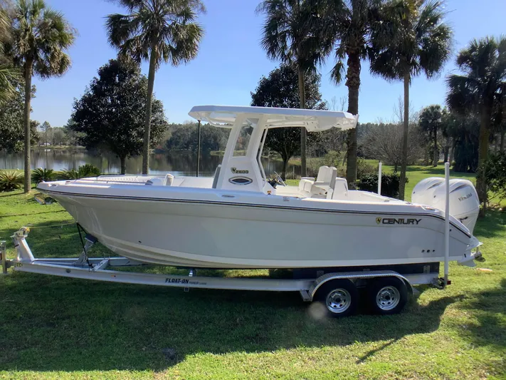 Highly Upgraded - 2025 Century 2600 Cc Yacht Photos Pics 2025 Century 2600 Center Console boat on trailer, parked on grass with palm trees in background.