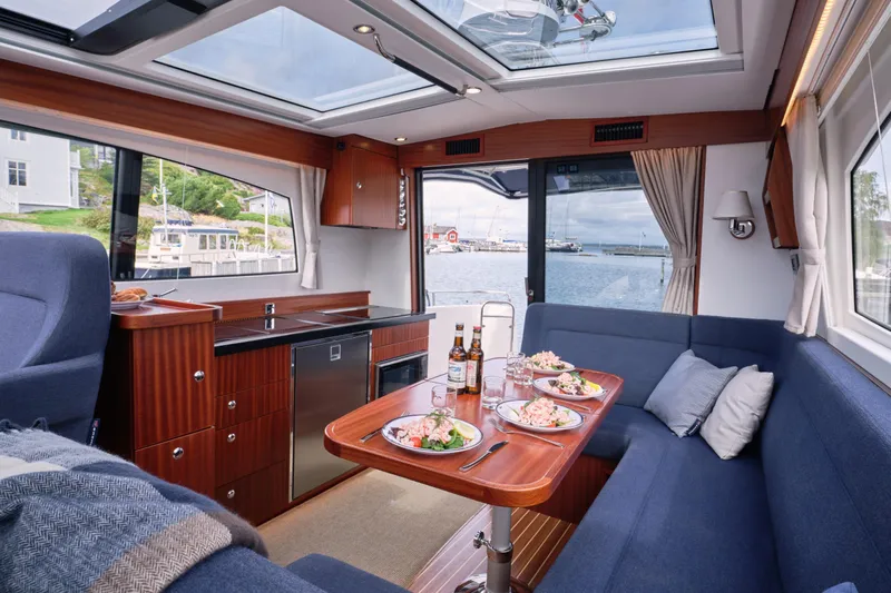  Yacht Photos Pics Luxurious interior of 2026 Nimbus 405 Coup&eacute; yacht with dining setup and scenic view.