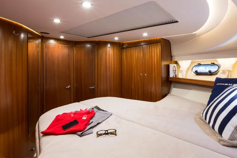  Yacht Photos Pics Luxurious cabin interior of 2026 Nimbus 405 Coup&eacute; with wood paneling and cozy bedding.
