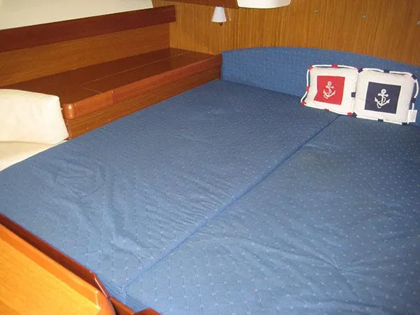 R Yacht Photos Pics Interior cabin of 2006 Jeanneau Sun Odyssey 42 DS with blue bedding and nautical-themed pillows.