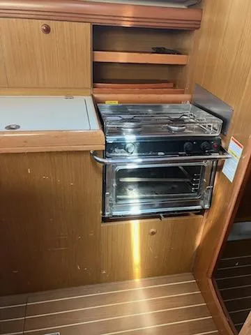 R Yacht Photos Pics 2006 Jeanneau Sun Odyssey 42 DS yacht kitchen with stove and wooden cabinetry.