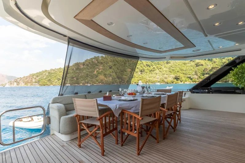  Yacht Photos Pics Luxurious dining area on 2016 Monte Carlo Yachts MCY 86, overlooking serene waters and lush greenery.