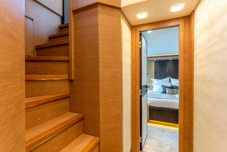  Yacht Photos Pics Interior of 2016 Monte Carlo Yachts MCY 86, featuring wooden stairs and a cozy bedroom.