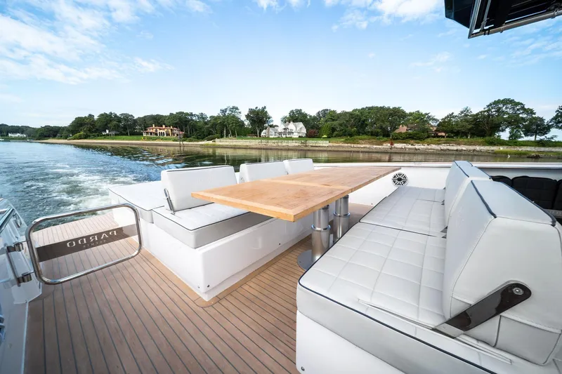 Lady Di Yacht Photos Pics 2024 Pardo Yachts 43 deck with seating and table, cruising near a scenic shoreline.