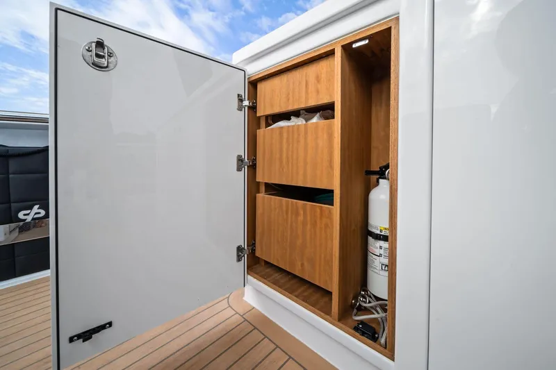 Lady Di Yacht Photos Pics Open storage compartment on 2024 Pardo Yachts 43, featuring shelves and a fire extinguisher.