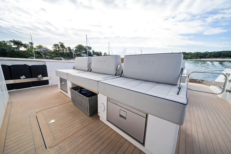 Lady Di Yacht Photos Pics 2024 Pardo Yachts 43 deck with cushioned seating and storage, docked by scenic shoreline.