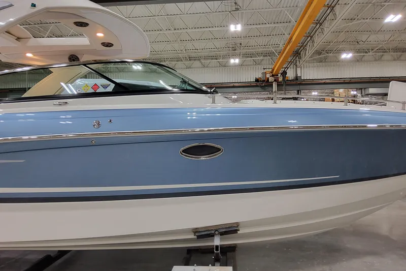  Yacht Photos Pics 2026 Formula 310 Bowrider OB in a showroom, showcasing sleek blue and white design.