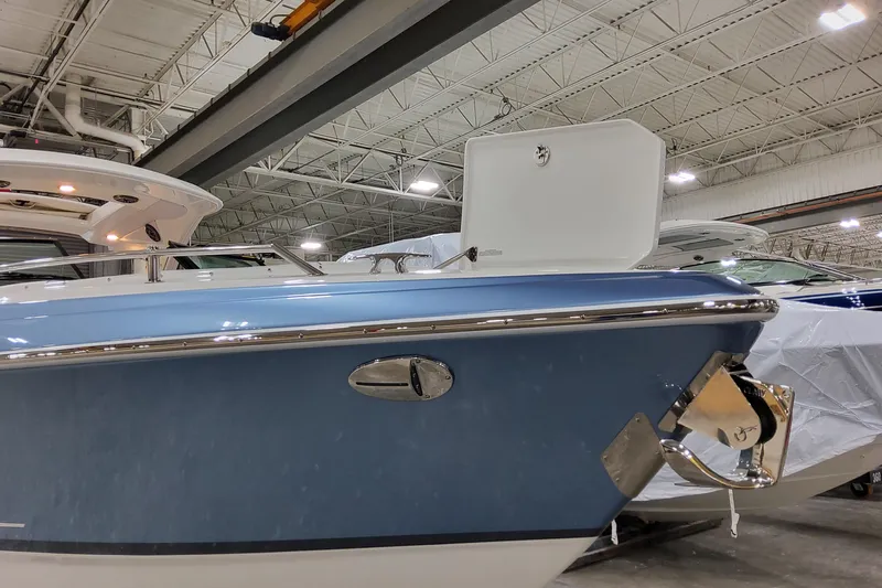  Yacht Photos Pics 2026 Formula 310 Bowrider OB in a showroom, showcasing sleek blue hull design.