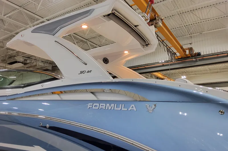  Yacht Photos Pics 2026 Formula 310 Bowrider OB boat in a showroom, showcasing sleek design and branding.