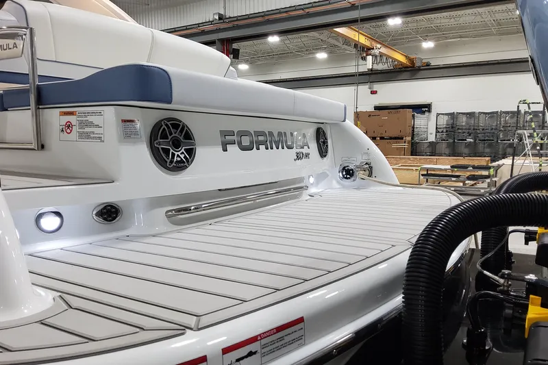 Yacht Photos Pics 2026 Formula 310 Bowrider OB boat in a workshop, showcasing sleek design and features.