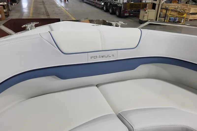  Yacht Photos Pics 2026 Formula 310 Bowrider OB boat interior with white and blue seating in a warehouse.