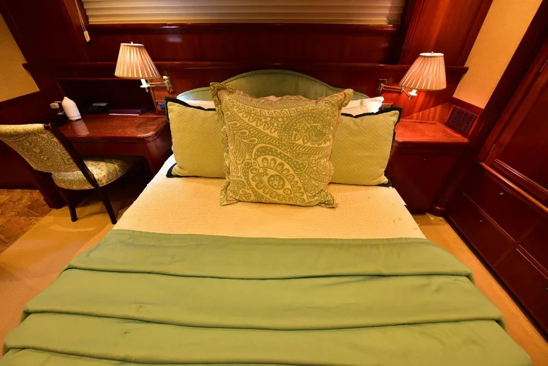 Waterford (name Reserved) Yacht Photos Pics Luxurious bedroom in 2016 Sovereign Pilothouse yacht with elegant green bedding and wooden decor.