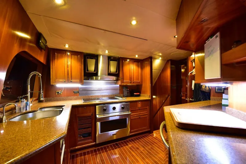Waterford (name Reserved) Yacht Photos Pics Luxurious yacht kitchen with wooden cabinetry, stainless steel appliances, and modern lighting.