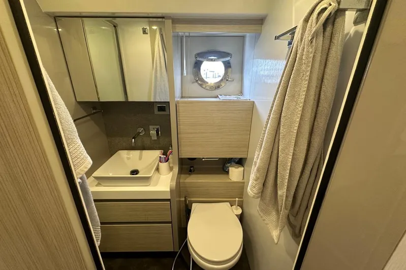  Yacht Photos Pics Modern bathroom in 2018 Cranchi E52F yacht with sink, toilet, and porthole window.
