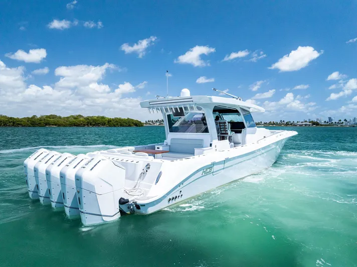 Yacht Photos Pics 2025 HCB 56' Sueños GIX luxury boat cruising on clear blue water under a sunny sky.