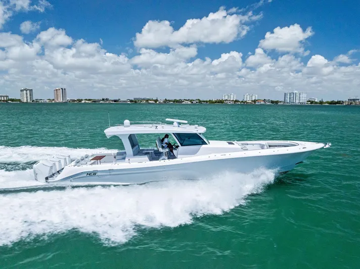  Yacht Photos Pics 2025 HCB 56' Sueños GIX cruising on turquoise water under a partly cloudy sky.