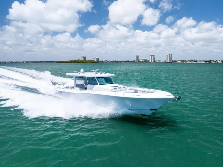  Yacht Photos Pics 2025 HCB 56' Sueños GIX yacht cruising on turquoise water under a blue sky.