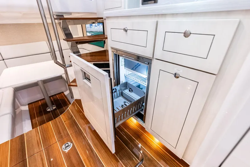  Yacht Photos Pics Luxurious interior of 2025 HCB 56' Sueños GIX yacht with open fridge and elegant wood flooring.