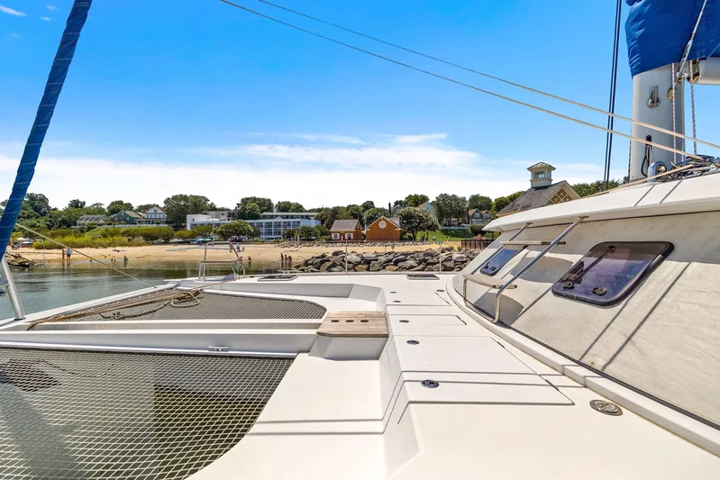 Vlaroda Yacht Photos Pics Nautitech 46 Open 2017 catamaran docked near a scenic shoreline under a clear blue sky.