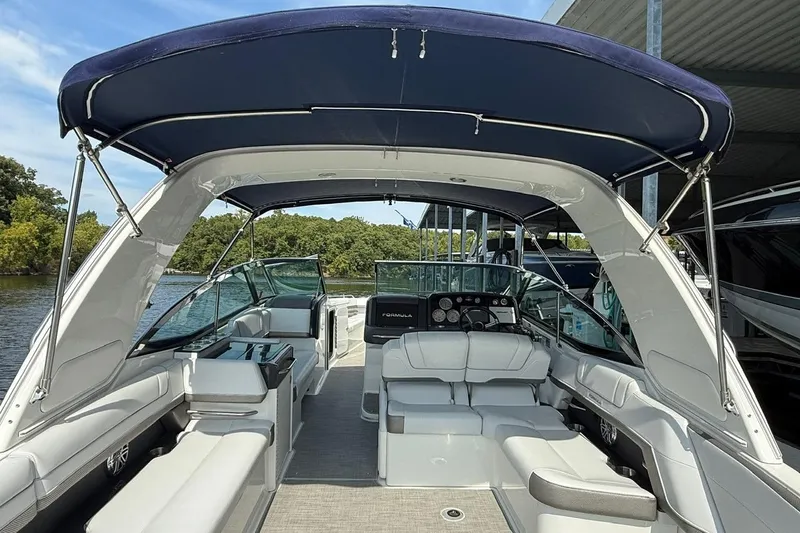  Yacht Photos Pics 2018 Formula 330 Crossover Bowrider with spacious seating and canopy, docked by the water.
