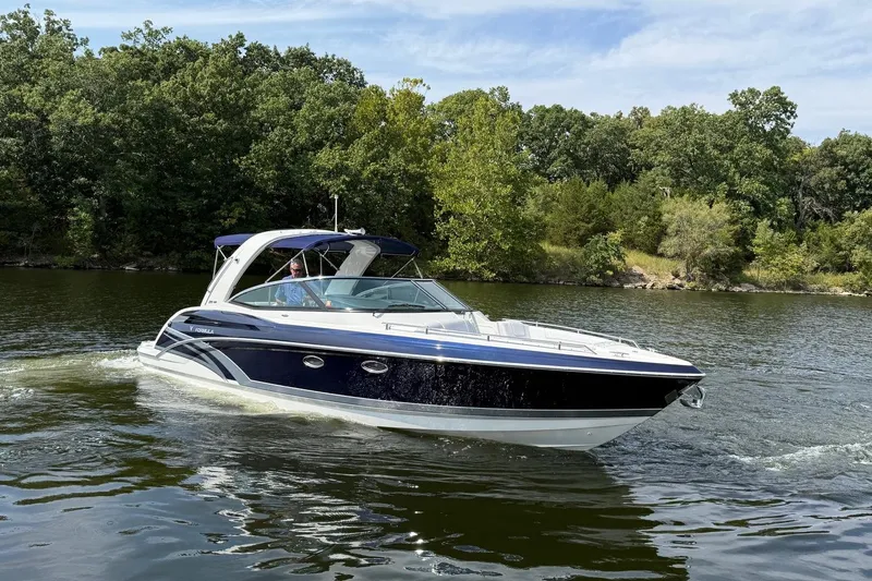  Yacht Photos Pics 2018 Formula 330 Crossover Bowrider cruising on a scenic lake with lush greenery.