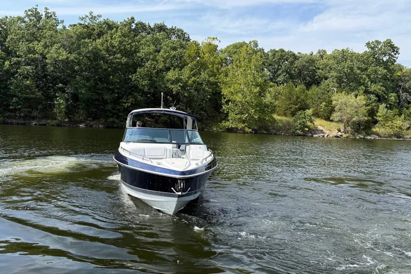  Yacht Photos Pics 2018 Formula 330 Crossover Bowrider cruising on a scenic lake with lush greenery.