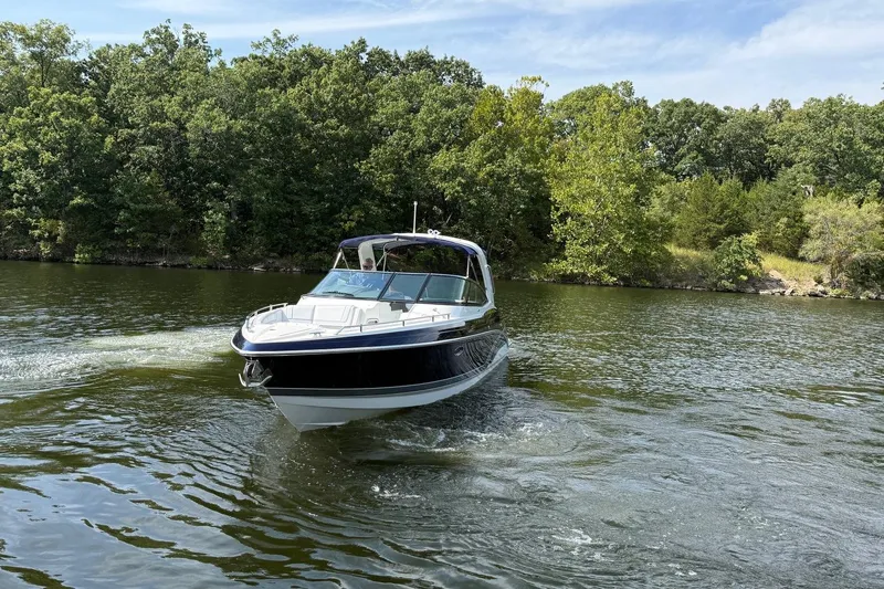  Yacht Photos Pics 2018 Formula 330 Crossover Bowrider cruising on a scenic lake with lush greenery.