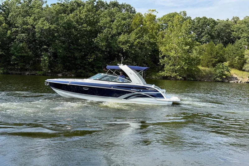  Yacht Photos Pics 2018 Formula 330 Crossover Bowrider cruising on a scenic lake with lush green trees.