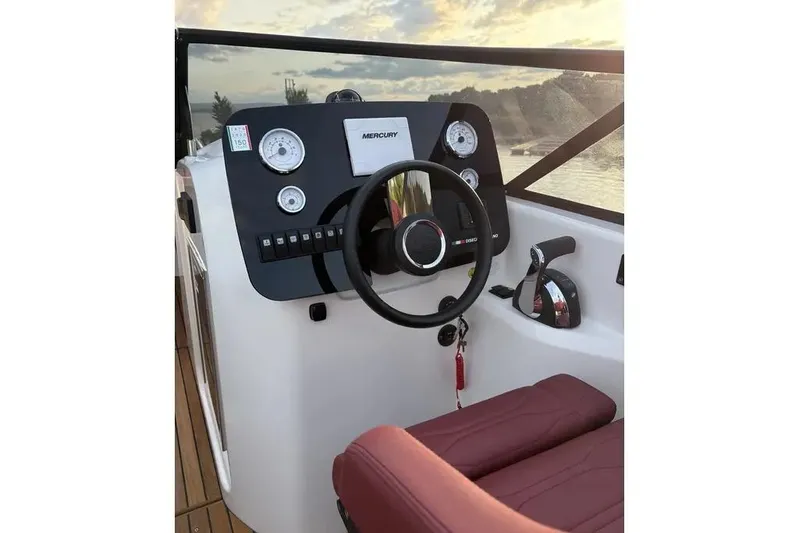  Yacht Photos Pics 2024 Cranchi E26 Classic boat dashboard with steering wheel and controls at sunset.