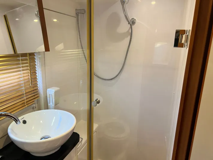  Yacht Photos Pics Modern bathroom in 2016 Aquila 48 yacht with sink, shower, and wooden blinds.