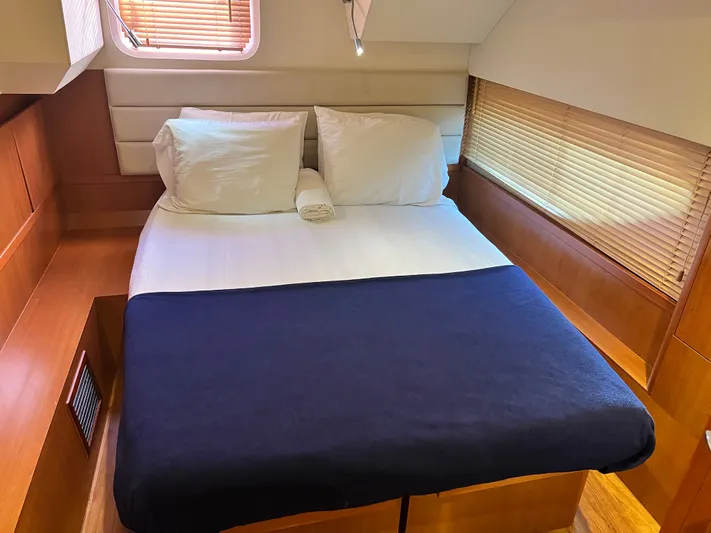  Yacht Photos Pics Cozy bedroom interior of 2016 Aquila 48 yacht with wooden accents and natural light.