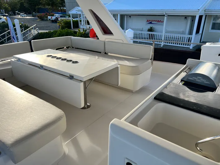  Yacht Photos Pics Luxurious seating area on 2016 Aquila 48 yacht with modern table and grill.