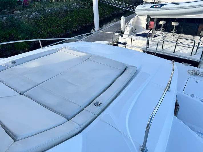  Yacht Photos Pics Aquila 48 yacht deck with cushioned seating, docked near greenery, 2016 model.