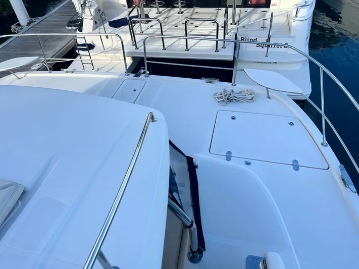  Yacht Photos Pics Aquila 48 yacht deck, 2016 model, with railing and docked boat in background.