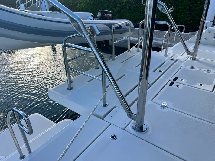  Yacht Photos Pics Aquila 48 yacht deck with stainless steel railings, docked beside calm water.