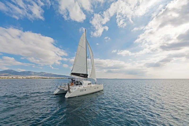  Yacht Photos Pics Sailing catamaran Lagoon 380 S2, 2017 model, gliding on open sea under blue sky.