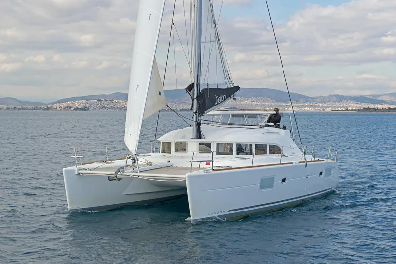  Yacht Photos Pics 2017 Lagoon 380 S2 catamaran sailing on calm waters with scenic coastal backdrop.