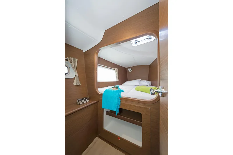  Yacht Photos Pics Cozy cabin interior of 2017 Lagoon 380 S2 catamaran with bed and window.