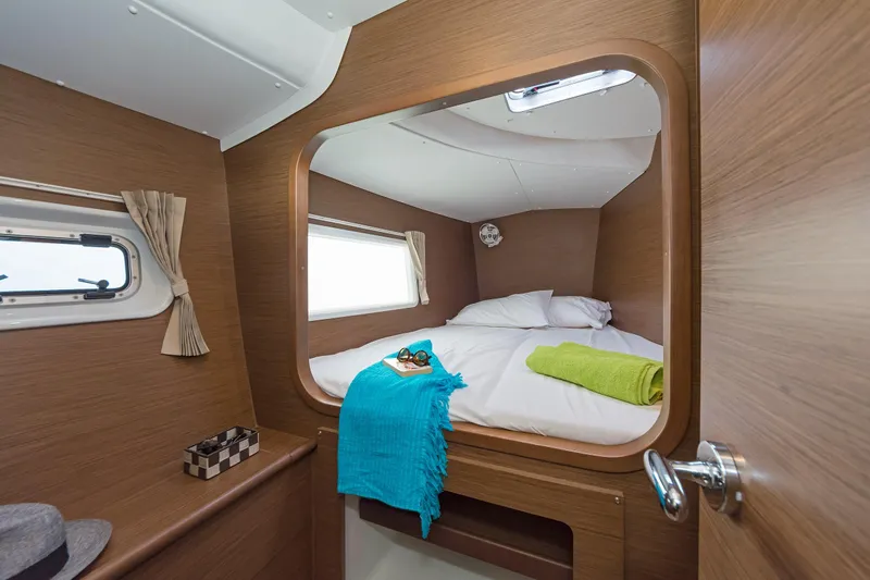  Yacht Photos Pics Cozy cabin interior of 2017 Lagoon 380 S2 catamaran with bed and porthole view.