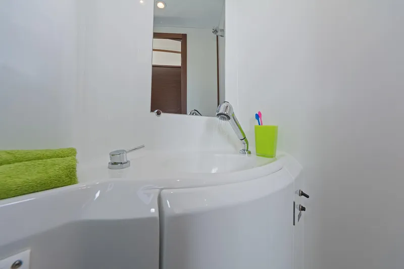  Yacht Photos Pics Bathroom sink area in 2017 Lagoon 380 S2 yacht with green towel and toothbrush holder.